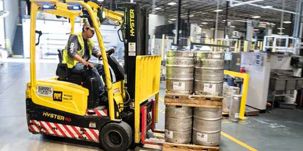 Persoon op een Heftruck verplaatst tonnen met gevaarlijke stoffen.