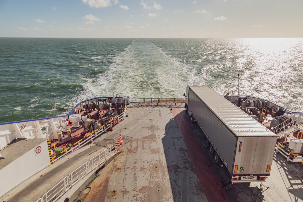 Vrachtwagen staat geparkeerd op een schip die aan het varen is.